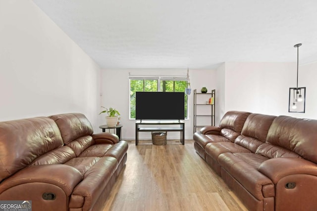 living area featuring light wood-style floors and baseboards