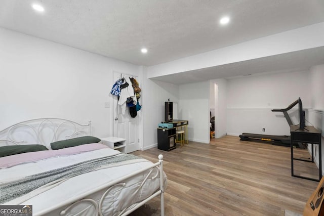 bedroom with recessed lighting, light wood-style floors, and baseboards