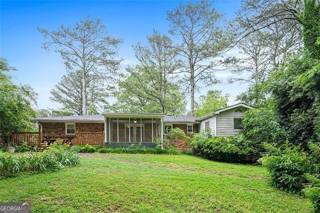 890 Oriole Ln, Marietta, GA 30067 - rear view of house with a sunroom, a lawn, brick siding, and a deck