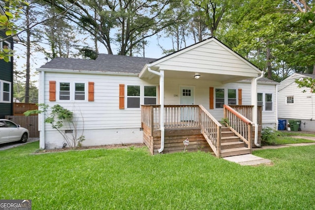 bungalow-style house with a front lawn, covered porch, and a shingled roof