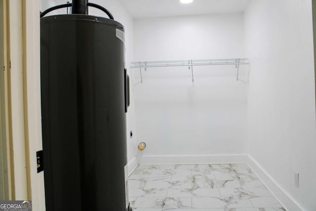 walk in closet with marble finish flooring and water heater