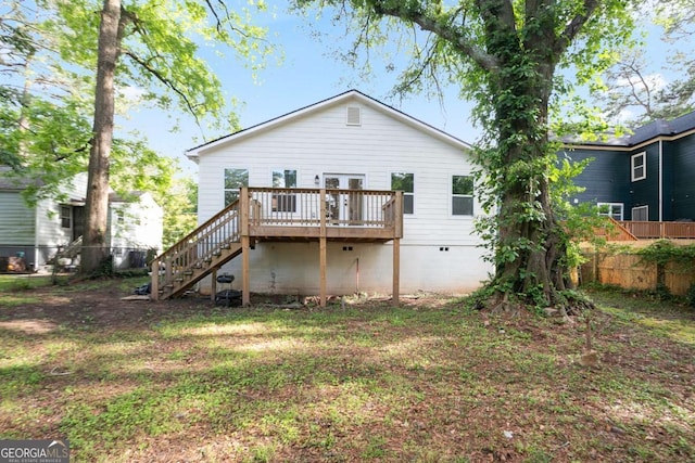 back of property with fence, a deck, stairway, and crawl space