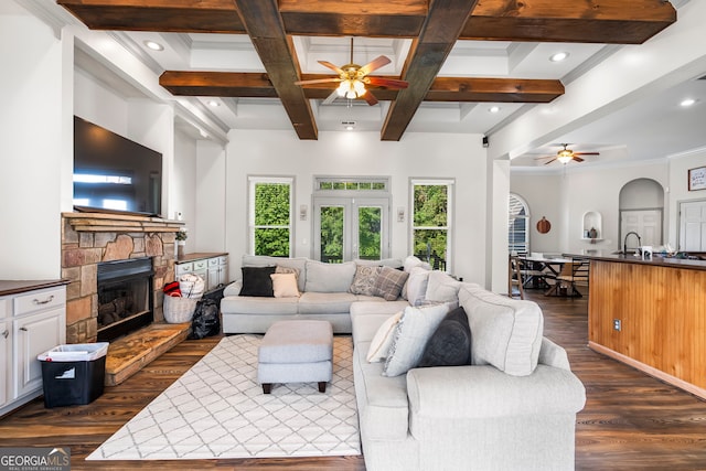 166 Freedom Ln, Commerce, GA 30530 - living room featuring ceiling fan, dark wood-type flooring, a stone fireplace, beam ceiling, and coffered ceiling