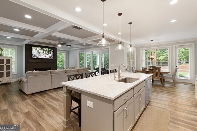 1050 Forrest Highlands, Greensboro, GA 30642 - kitchen featuring a sink, stainless steel dishwasher, a large fireplace, light wood-style flooring, and a kitchen breakfast bar