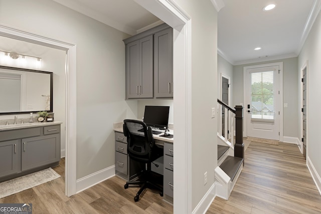 1050 Forrest Highlands, Greensboro, GA 30642 - office area with crown molding, a sink, light wood-style floors, baseboards, and built in study area