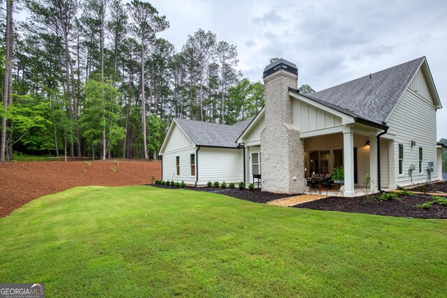 1050 Forrest Highlands, Greensboro, GA 30642 - back of property with a chimney, board and batten siding, roof with shingles, and a lawn