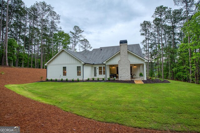 1050 Forrest Highlands, Greensboro, GA 30642 - rear view of property with board and batten siding, a chimney, a yard, and a shingled roof