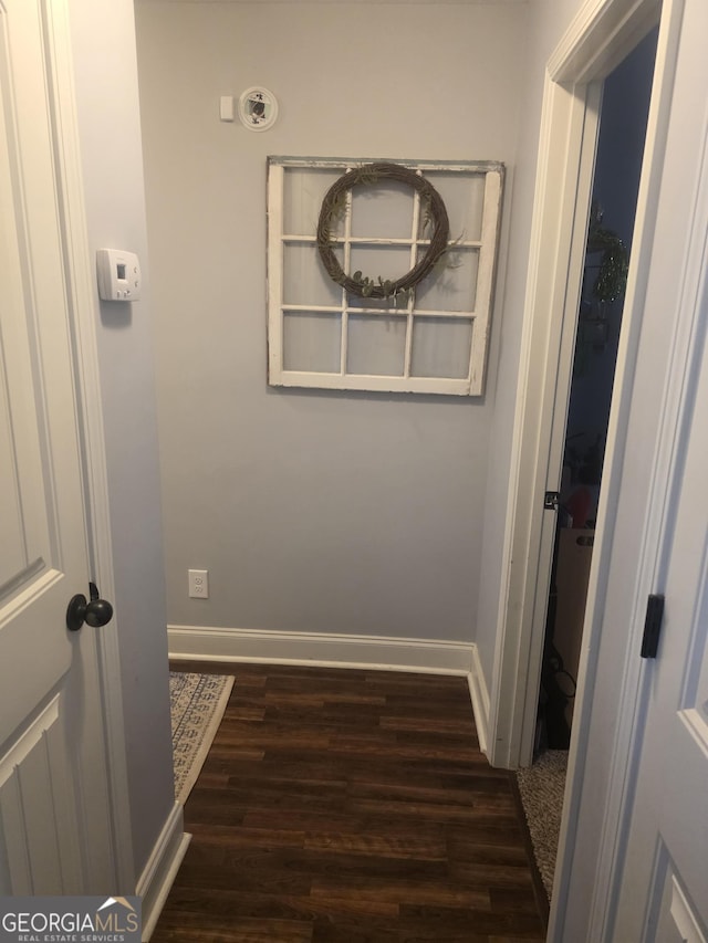 hall featuring wood finished floors and baseboards