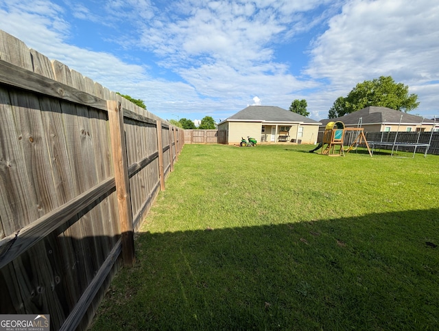 view of yard with a playground and a trampoline