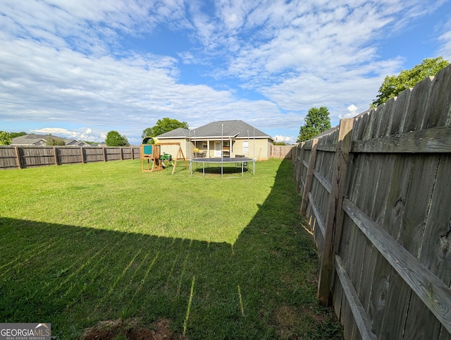 view of yard featuring a playground and a trampoline