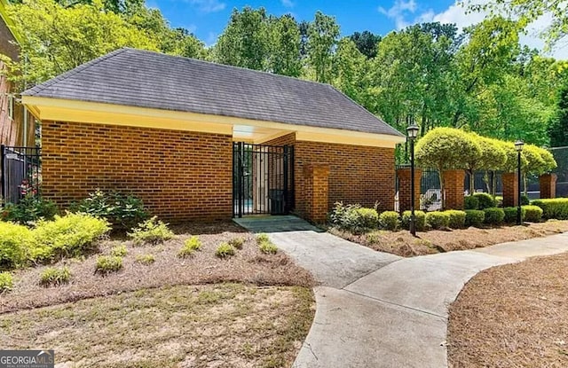 232 Spalding Gates Dr, Atlanta, GA 30328 - view of front facade featuring fence, brick siding, a gate, and roof with shingles