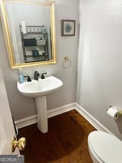 232 Spalding Gates Dr, Atlanta, GA 30328 - bathroom featuring baseboards, toilet, and wood finished floors