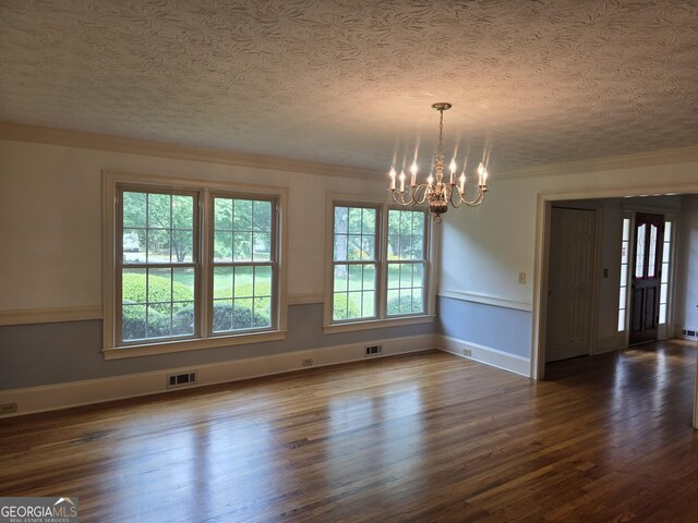 2451 Old Salem Cir SE, Conyers, GA 30013 - unfurnished dining area with a chandelier, dark wood-type flooring, a textured ceiling, crown molding, and baseboards