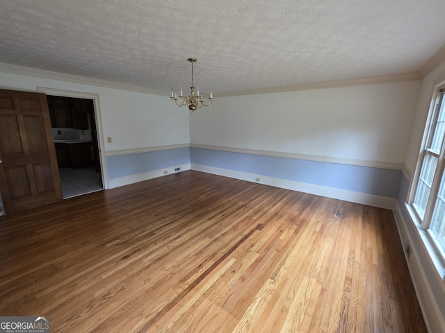 2451 Old Salem Cir SE, Conyers, GA 30013 - unfurnished dining area with a chandelier, wood finished floors, a textured ceiling, ornamental molding, and baseboards