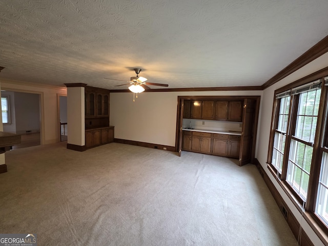 2451 Old Salem Cir SE, Conyers, GA 30013 - unfurnished living room with baseboards, a ceiling fan, ornamental molding, light colored carpet, and a textured ceiling
