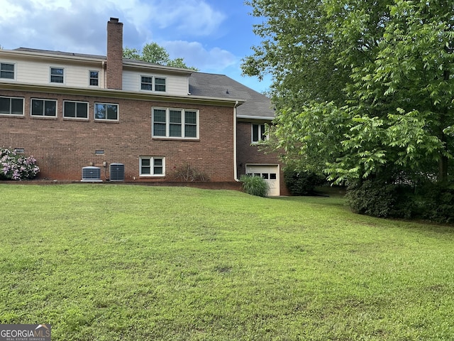 2451 Old Salem Cir SE, Conyers, GA 30013 - back of property with a chimney, central AC, a lawn, and brick siding