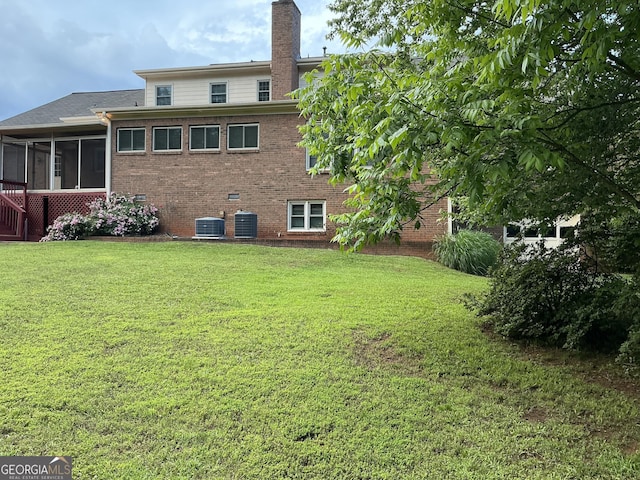 2451 Old Salem Cir SE, Conyers, GA 30013 - back of house featuring a sunroom, central AC, brick siding, and a yard