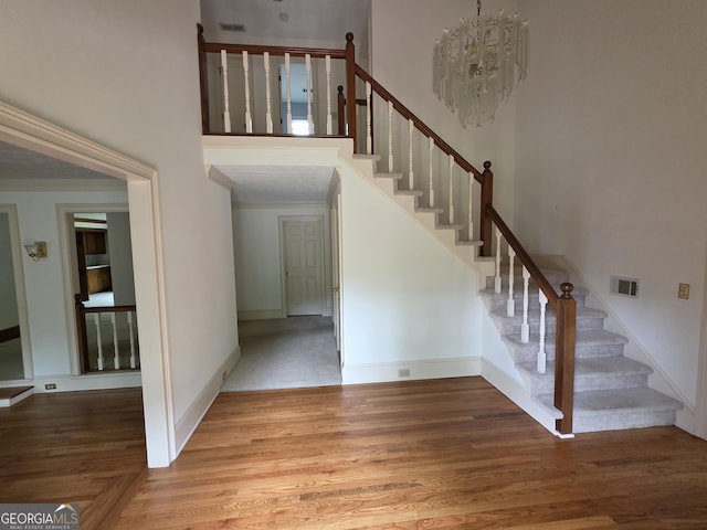 2451 Old Salem Cir SE, Conyers, GA 30013 - stairway with wood finished floors, a towering ceiling, crown molding, baseboards, and a chandelier