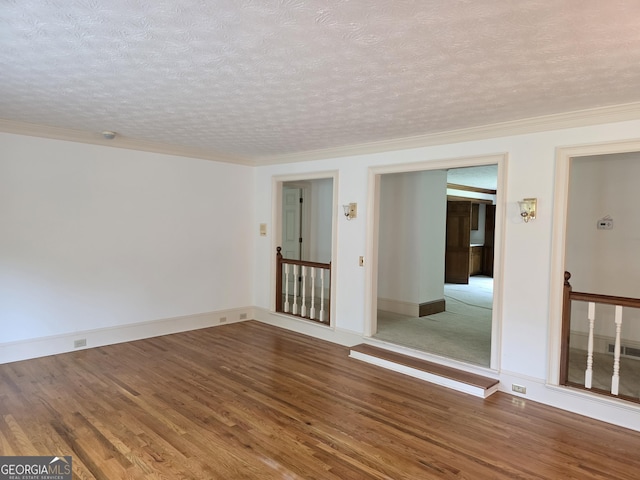 2451 Old Salem Cir SE, Conyers, GA 30013 - spare room featuring wood finished floors, a textured ceiling, baseboards, and ornamental molding