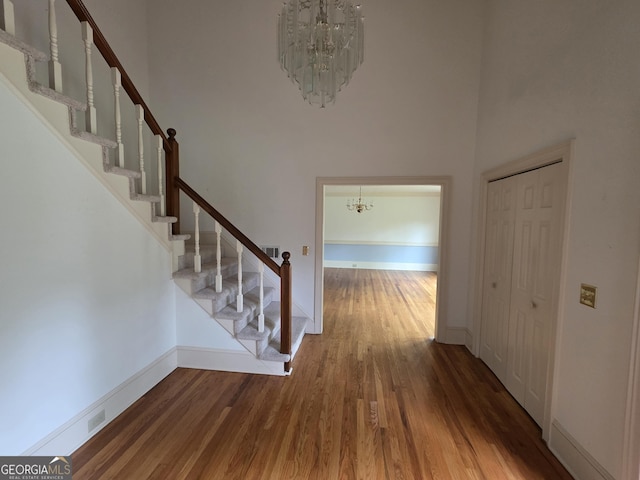 2451 Old Salem Cir SE, Conyers, GA 30013 - hallway with a chandelier, a towering ceiling, wood finished floors, stairway, and baseboards