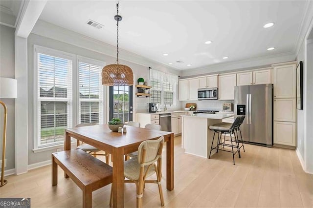 dining space featuring ornamental molding, baseboards, light wood finished floors, and recessed lighting