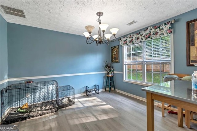 575 Chapel Walk, Lawrenceville, GA 30045 - dining space with a chandelier, wood finished floors, and a textured ceiling