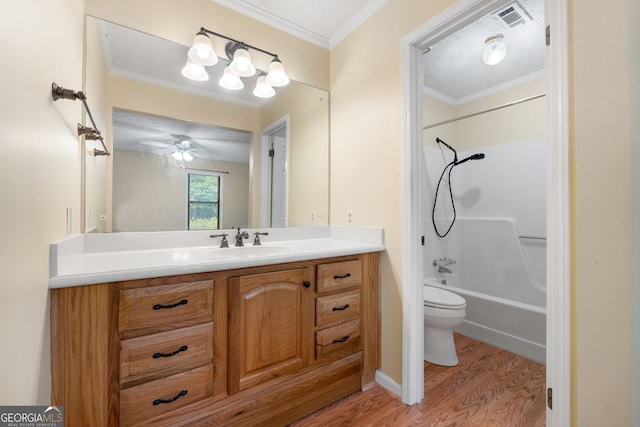 bathroom with wood finished floors, toilet, vanity, ceiling fan, and shower / bathtub combination