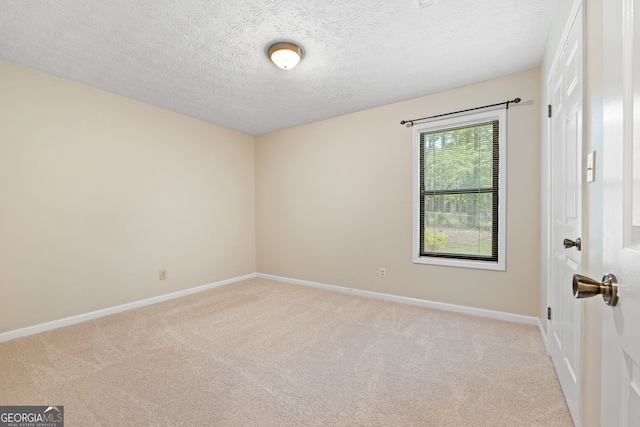 unfurnished room featuring light colored carpet, baseboards, and a textured ceiling