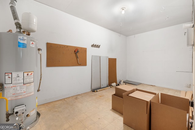 interior space with gas water heater, light flooring, and baseboards