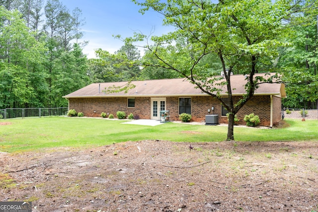 back of property with central air condition unit, brick siding, a patio, and french doors
