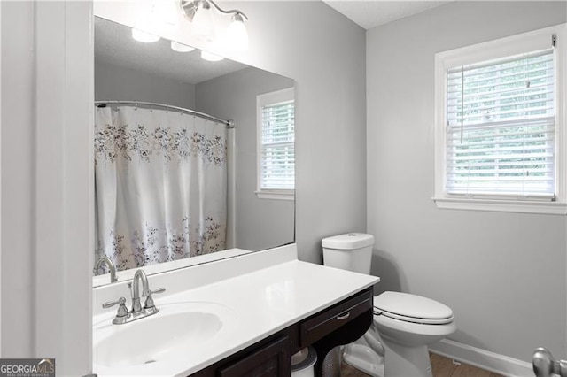 full bathroom featuring toilet, vanity, and baseboards