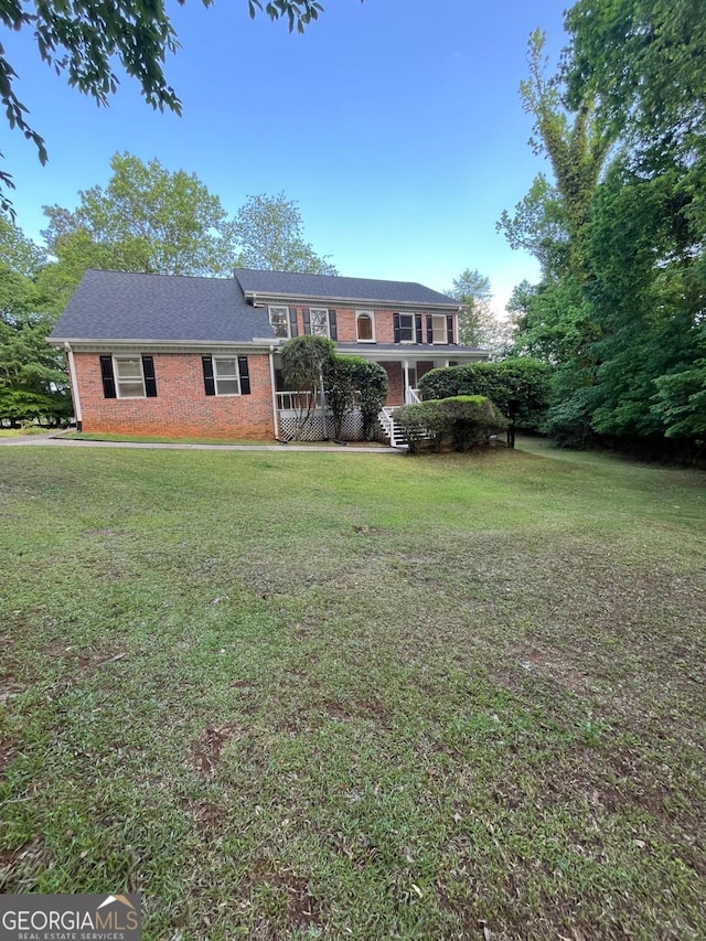 view of front of house featuring brick siding and a front lawn
