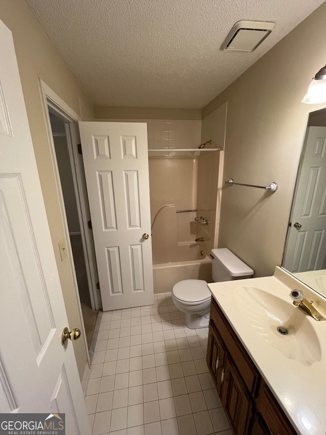 bathroom with a textured ceiling, toilet,  shower combination, vanity, and tile patterned floors