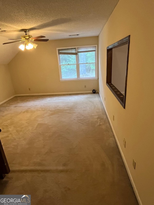 bonus room with carpet floors, baseboards, ceiling fan, a textured ceiling, and vaulted ceiling