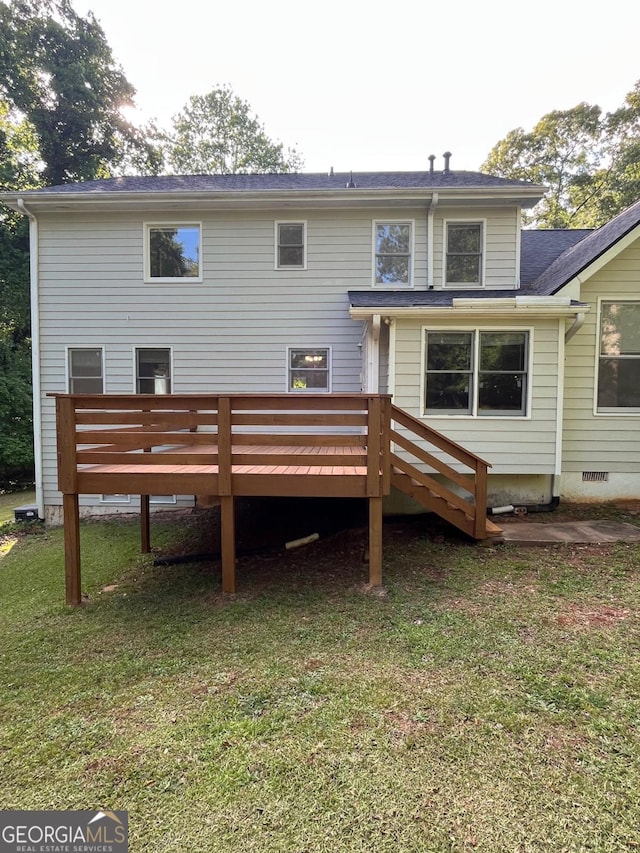 rear view of property featuring a deck, a lawn, and crawl space