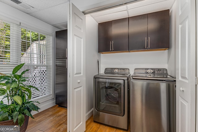 3835 Annandale Ln, Suwanee, GA 30024 - laundry area with washing machine and dryer, cabinet space, light wood-type flooring, and baseboards