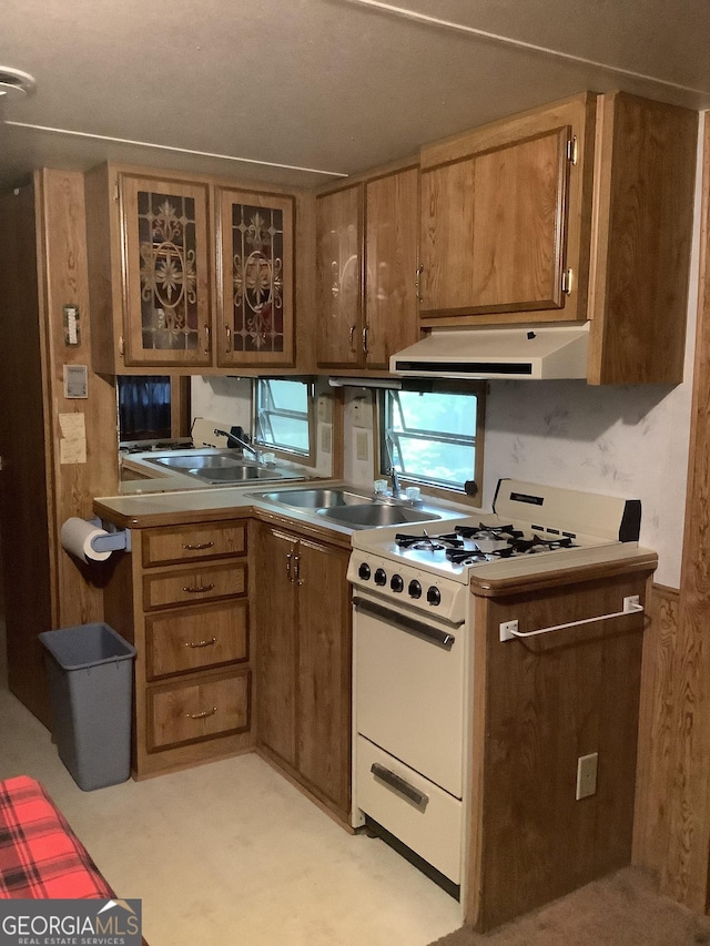 961 Mountain Shadows Dr, Cleveland, GA 30528 - kitchen with white gas range, range hood, glass insert cabinets, a sink, and brown cabinets