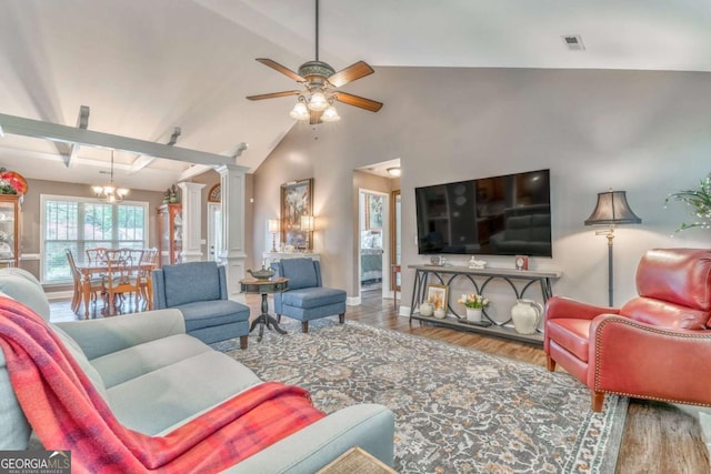 living room featuring ceiling fan, wood finished floors, decorative columns, a chandelier, and lofted ceiling