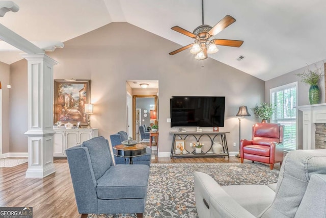 living area featuring decorative columns, lofted ceiling, ceiling fan, light wood-type flooring, and baseboards