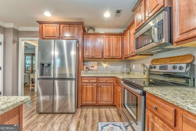 kitchen featuring appliances with stainless steel finishes, light wood-style floors, ornamental molding, brown cabinetry, and light stone counters
