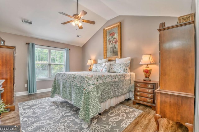 bedroom with lofted ceiling, wood finished floors, a ceiling fan, and baseboards