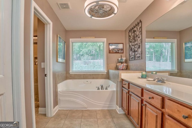 full bathroom with tile patterned flooring, a bath, and vanity