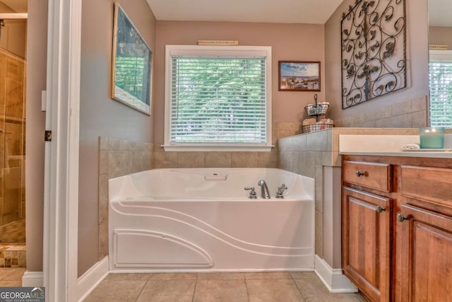 bathroom with healthy amount of natural light, a garden tub, tile patterned floors, and tiled shower