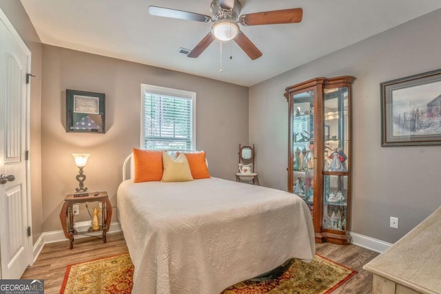 bedroom featuring wood finished floors, baseboards, and a ceiling fan