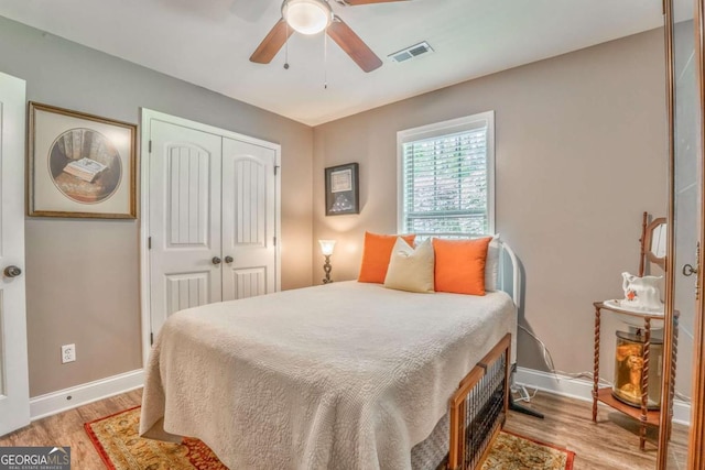 bedroom with light wood-type flooring, a closet, and baseboards