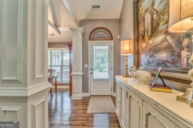 doorway to outside featuring ornate columns, dark wood-style floors, and baseboards