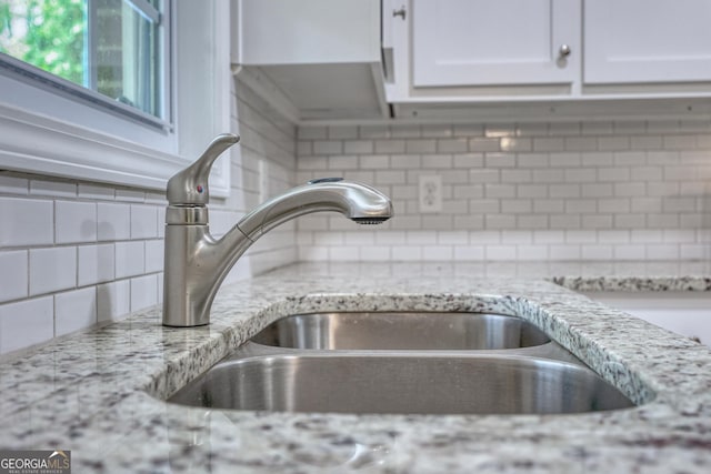 132 Jefferson Dr, Columbus, GA 31907 - kitchen view of a sink, tasteful backsplash, white cabinetry, and light stone countertops