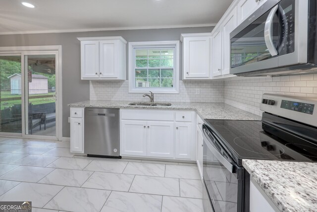 132 Jefferson Dr, Columbus, GA 31907 - kitchen with stainless steel appliances, a sink, white cabinets, ornamental molding, and light stone countertops