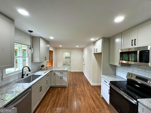 3340 Zingara Rd, Conyers, GA 30012 - kitchen featuring appliances with stainless steel finishes, a sink, dark wood-style flooring, backsplash, and light stone counters