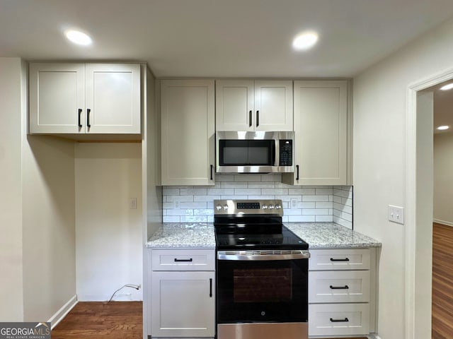 3340 Zingara Rd, Conyers, GA 30012 - kitchen with stainless steel appliances, dark wood-type flooring, decorative backsplash, light stone counters, and recessed lighting